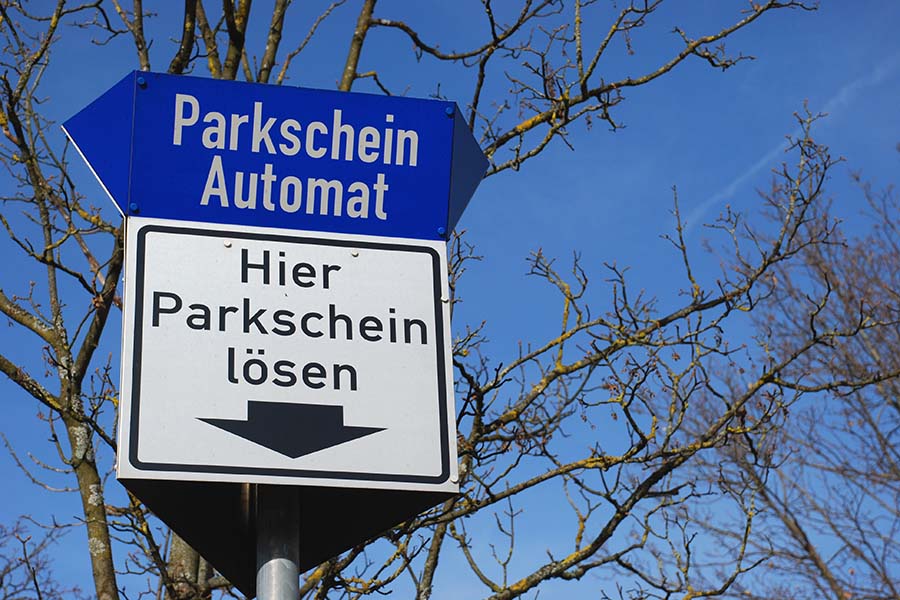 Schilder mit der Aufschrift Hier Parkschein lösen und Parkschein Automat