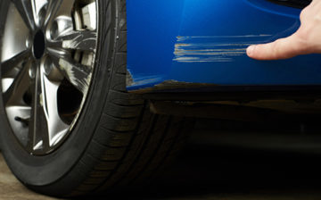 Kratzer an einem blauen Auto am Heck