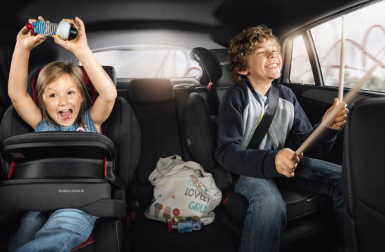Zwei Kinder sitzen auf der Rückbank in einem Auto