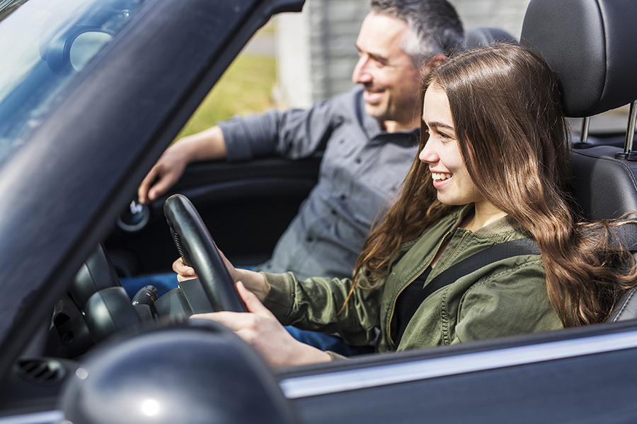 Fahrlehrer und Fahrschülerin sitzen in einem Auto