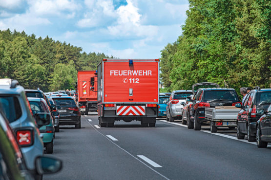 Autos bilden auf einer Autobahn eine Rettungsgasse und lassen die Feuerwehr durch fahren