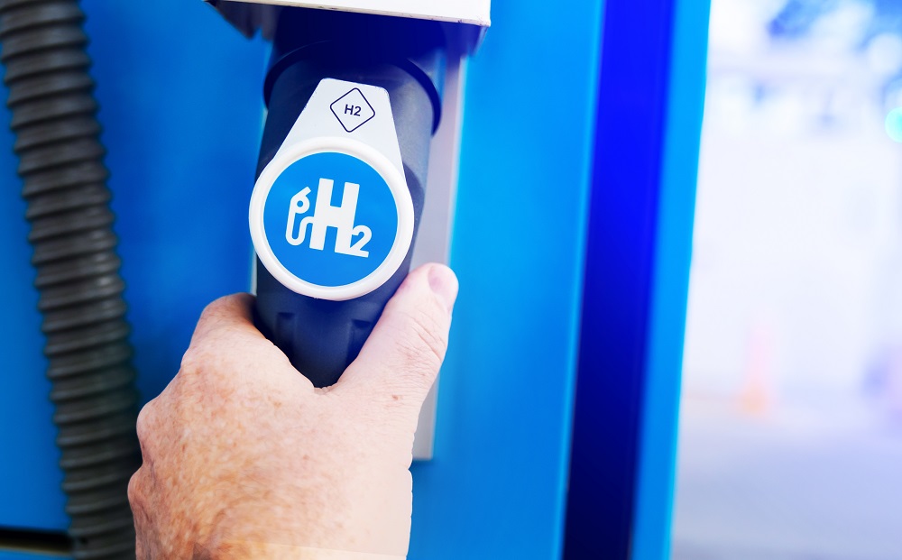 hand hält einen zapfhahn auf dem h2o steht